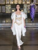 Model wearing ivory and gold hand-embroidered draped set with sculpted sheer sleeves from Cloud Devotion by Saanjh by Saloni at London Fashion Week 2026.